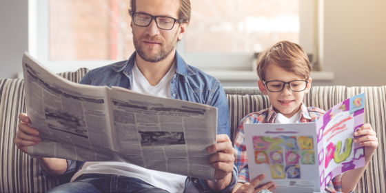 Vuxen och barn tittar i varsin skrift