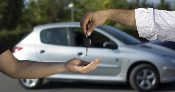 Dekorbild på bilnycklar som överlämnas från en person till en annan.